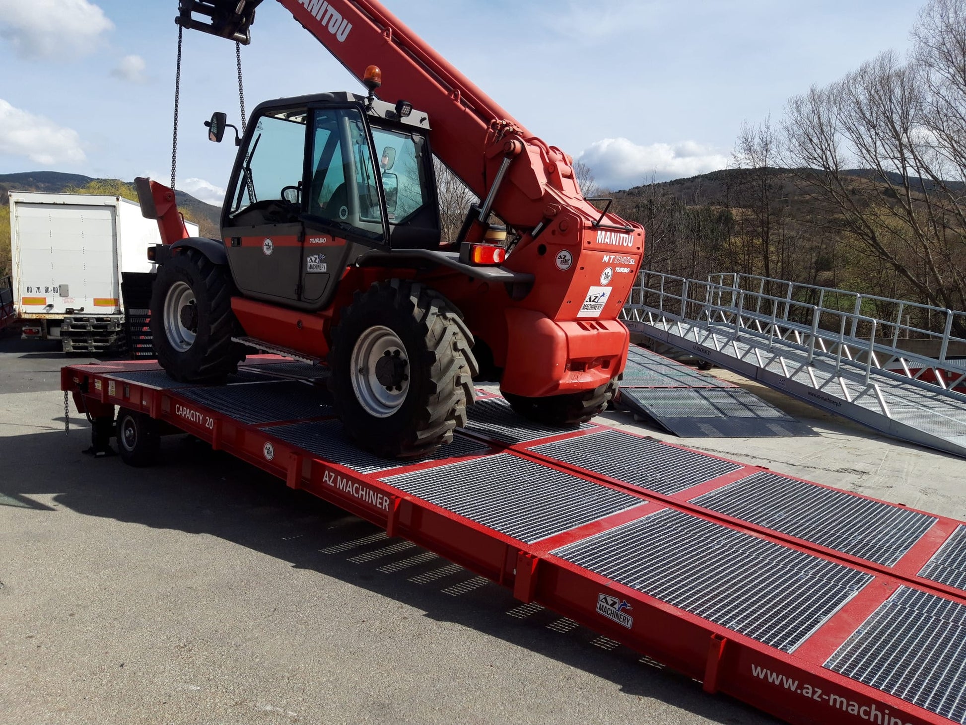 La fotografía presenta la imponente rampa Big Foot de AZ RAMP en plena ejecución. Con una capacidad de carga de 20 toneladas, este dispositivo móvil está diseñado para proporcionar una solución sólida y versátil para una variedad de aplicaciones industriales. Su estructura resistente y su diseño inteligente la convierten en una opción ideal para la manipulación de cargas pesadas en entornos desafiantes.