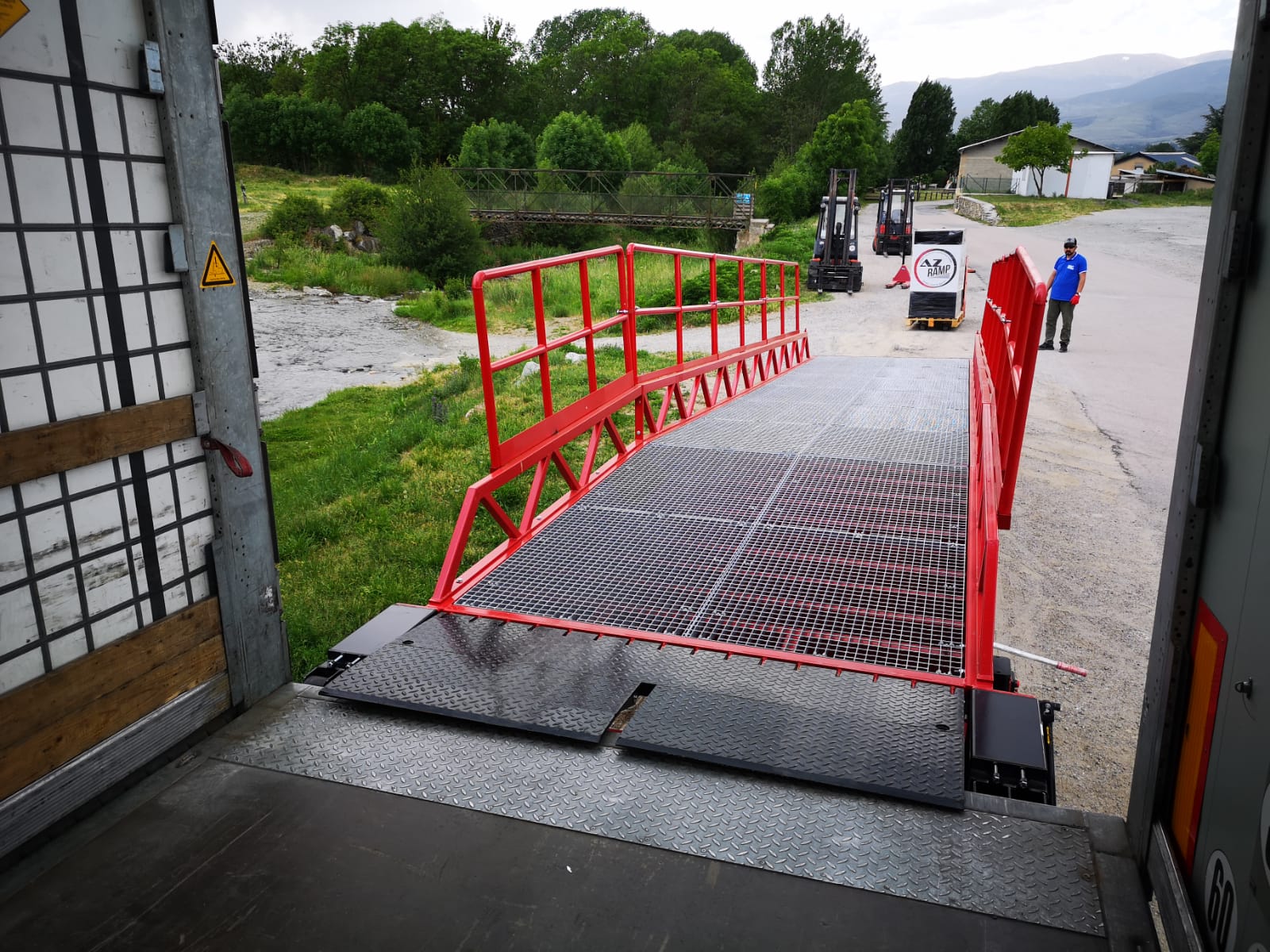 La foto muestra la rampa móvil STAR OTC en pleno funcionamiento, facilitando el carga y descarga de mercancías con eficiencia y seguridad. Su capacidad de 10 000 kg la hace ideal para diversas aplicaciones industriales y logísticas.